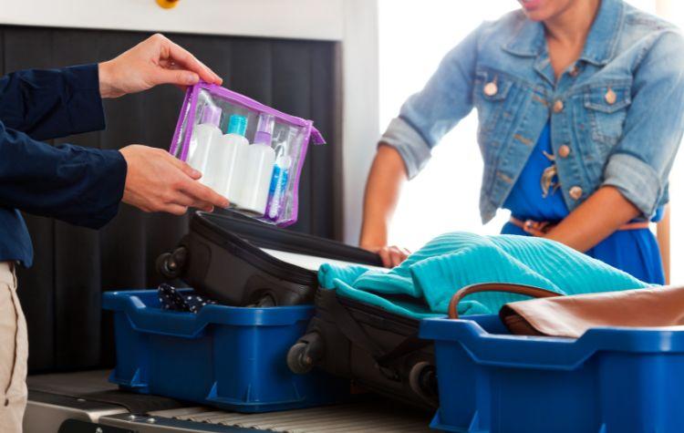 A clear bag with TSA-compliant liquids being taken out of a suitcase