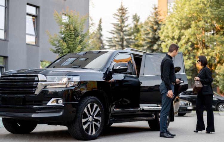 A woman getting into her black car ride