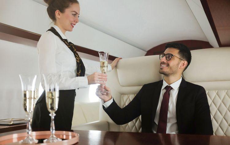 Attendant serves a passenger in first class