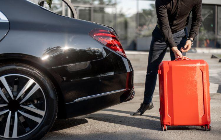 Chauffeur loading luggage into a black car