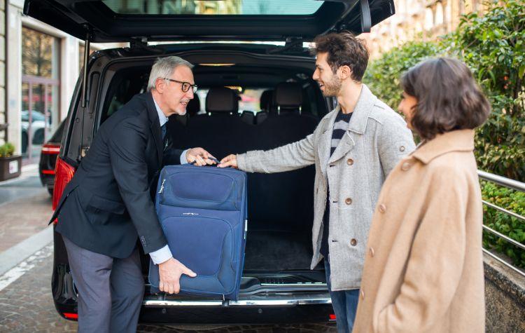 Chauffeur loading luggage into a black car