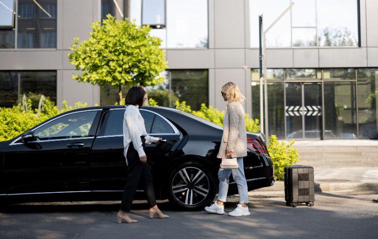 Chauffeur opening the door to a black car vehicle