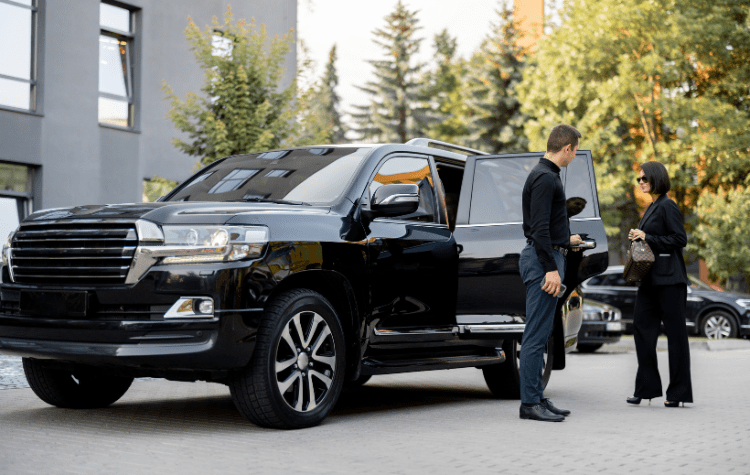 A business lady getting in a Black Car