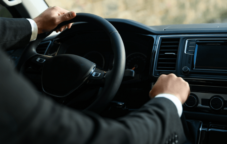 A man driving a black car