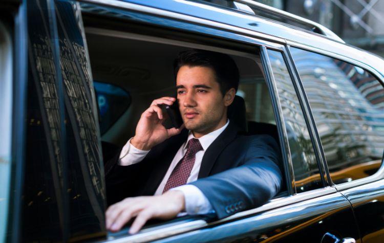 A business man in the back seat of black car.