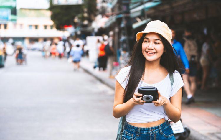 Girl on vacation with an instant camera