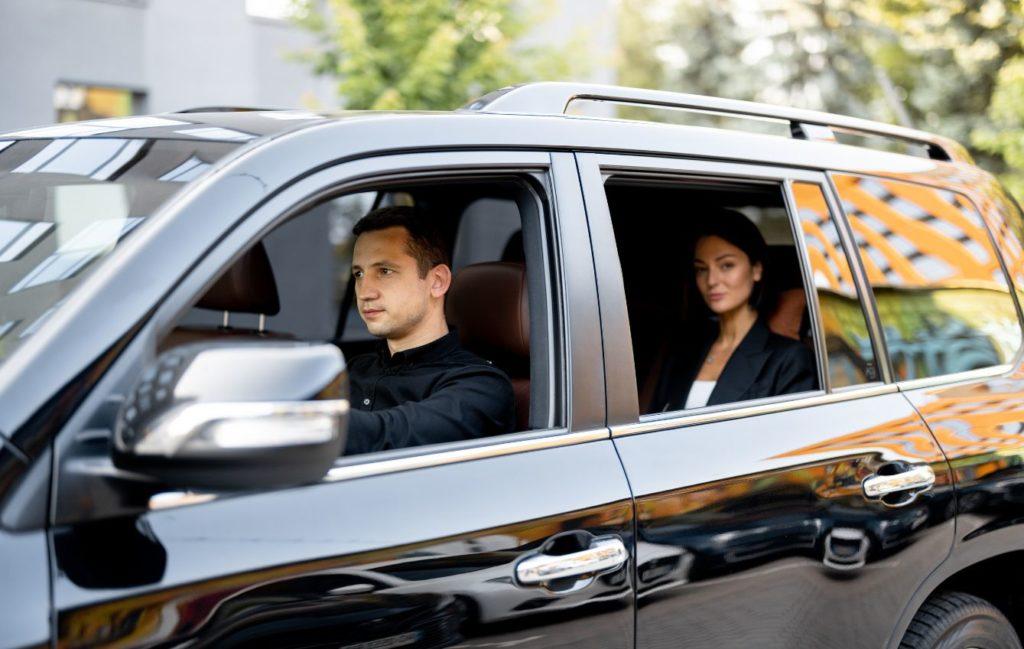 A business women in black car on back seat