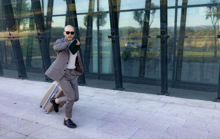 Man checking watch as he rushes somewhere with luggage