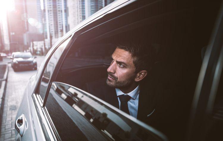 Man looking out at the city from inside a car