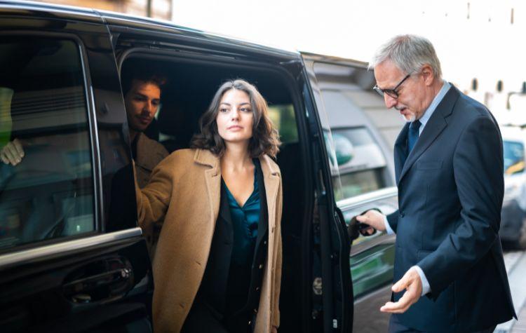 Woman stepping out of a black car transport