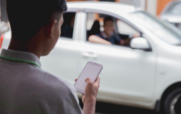 Person checking their phone as their driver arrives