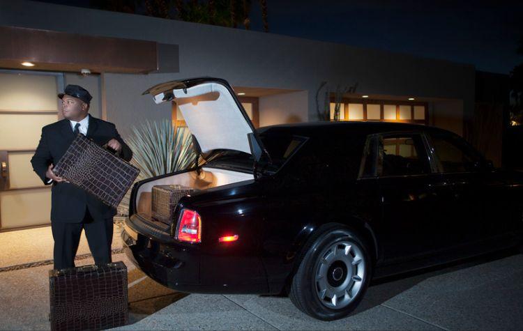 Chauffeur placing luggage into car