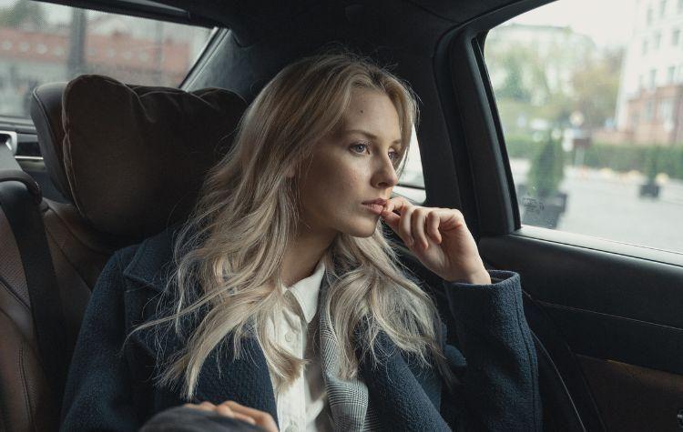 A girl siting in the back seat of a car