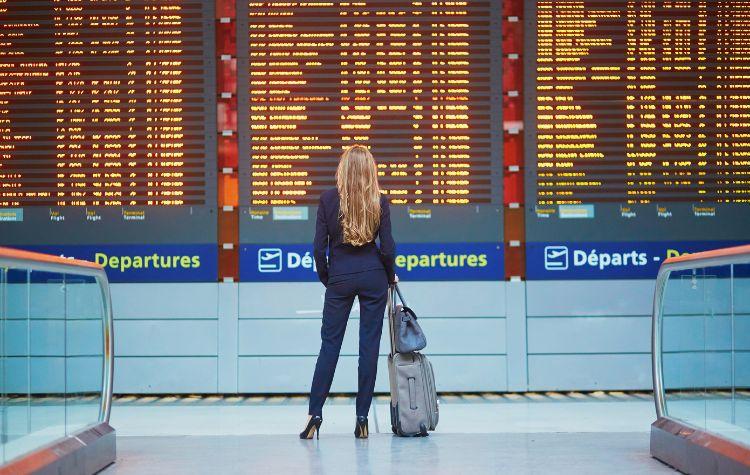 Woman looking at the airport marquee of flights