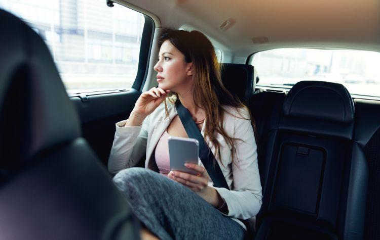 Woman riding in the back of a luxury car